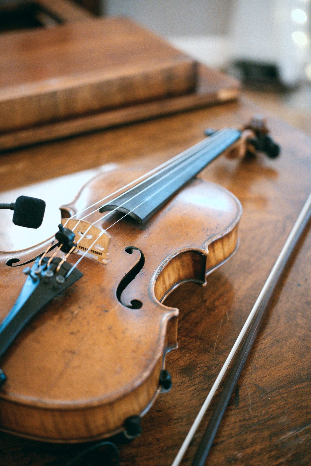 A violin and bow resting on a wooden bench